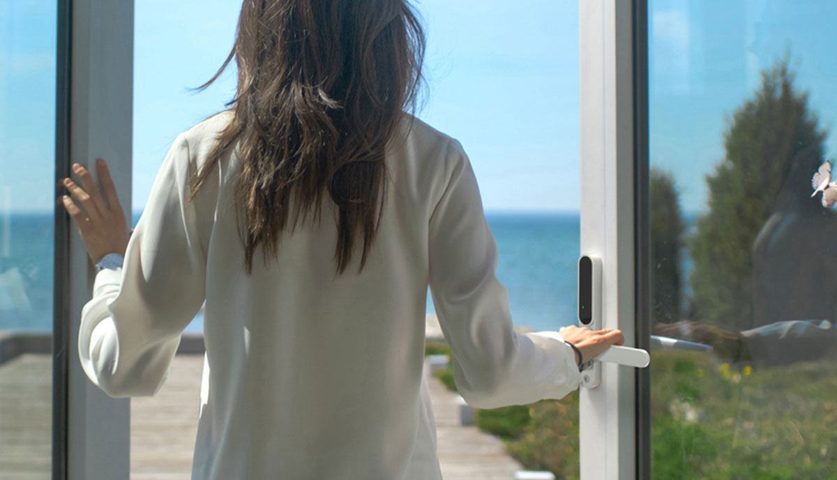 Woman operating the SecuYou Smart Lock on a patio door